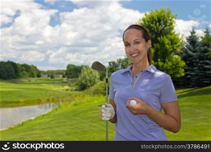 Female golfer with golf club and ball on the fairway