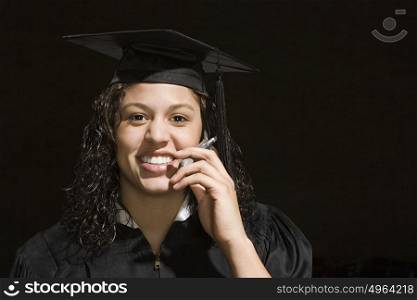 Female graduate using a cellular telephone
