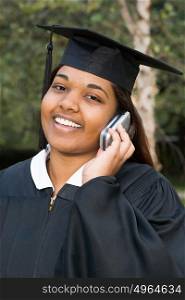 Female graduate using a cellular telephone