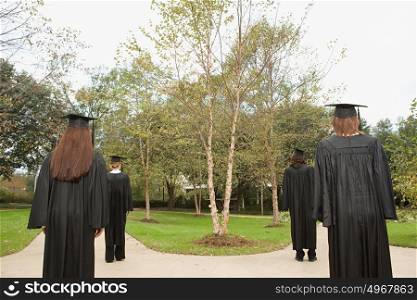 Female graduates walking down paths