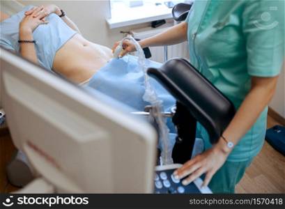 Female gynecologist makes ultrasound scan. Gynecological examination in clinic, gynecology consultation, ultrasonography diagnostic or scanning. Doctor in hospital. Female gynecologist makes ultrasound scan