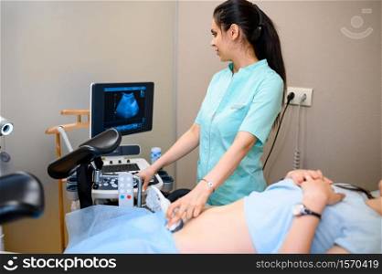 Female gynecologist makes ultrasound scan. Gynecological examination in clinic, gynecology consultation, ultrasonography diagnostic or scanning. Doctor and woman in hospital. Female gynecologist makes ultrasound scan