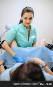 Female gynecologist works with patient in chair. Gynecological examination in clinic, gynecology diagnostic or consultation, exam. Doctor and woman in hospital. Female gynecologist works with patient in chair