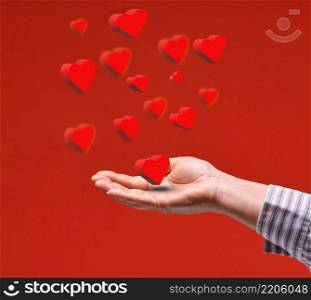 female hand and red flying hearts on a red background. Happy Valentine’s Day