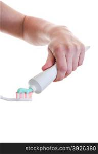 Female hand applying Toothpaste to tooth brush isolated over white with copy-space