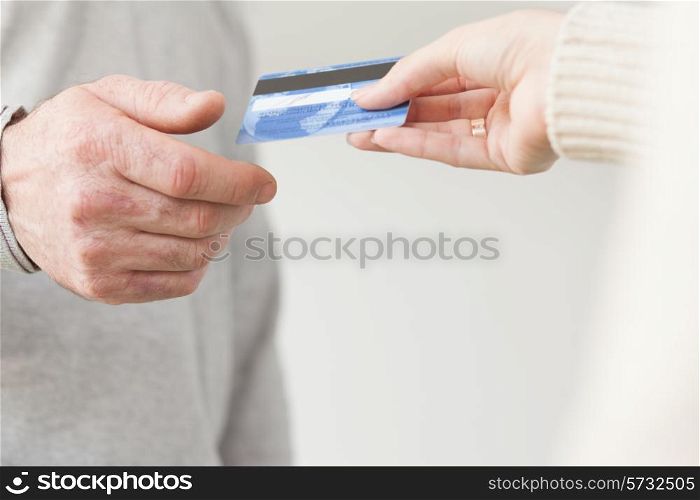 Female hand giving a plastic card to senior male hand