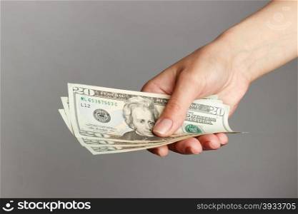 Female hand holding a 20 Dolar, on a dark background