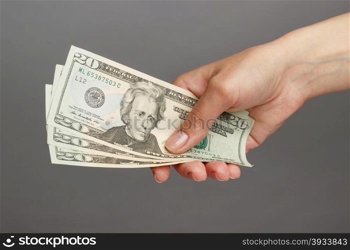 Female hand holding a 20 Dolar, on a dark background