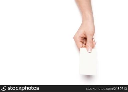 Female hand holding a blank business card over white background.. Female hand holding a blank business card over white background