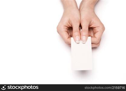 Female hand holding a blank business card over white background.. Female hand holding a blank business card over white background