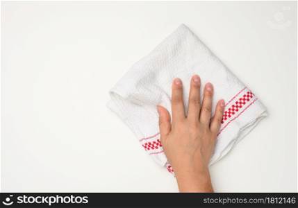female hand holding a white kitchen towel on a white table, top view