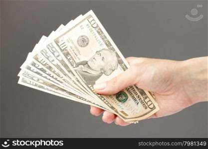 female hand holding money bills on a gray background. female hand holding money
