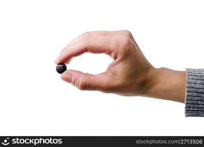 Female hand holding one gray pill