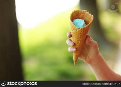 Female hand holding wafer cone with blue ice cream. Close up, High resolution product. blue ice cream in hand. Female hand holding wafer cone with blue ice cream. Close up, High resolution product. blue ice cream in hand.