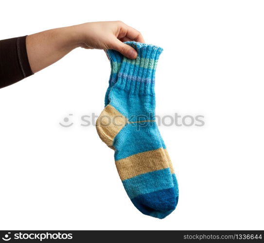 female hand holds a pair of knitted woolen socks, warm clothes, item is isolated on a white background