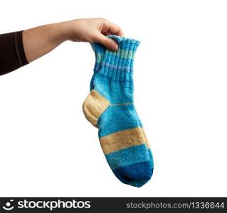 female hand holds a pair of knitted woolen socks, warm clothes, item is isolated on a white background