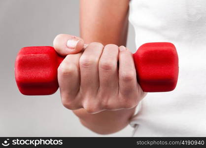 female hand is holding a red barbell