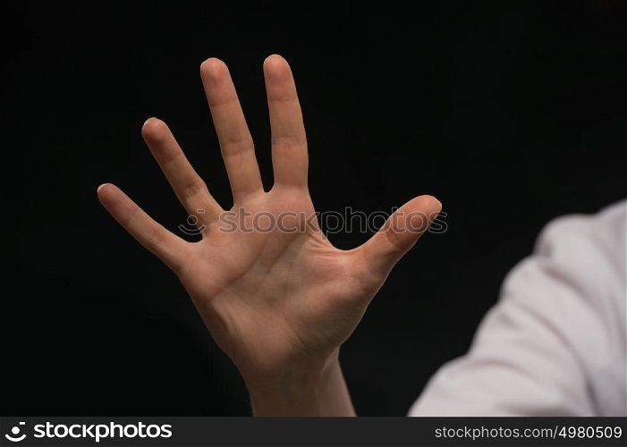 Female hand is showing five fingers isolated on black background