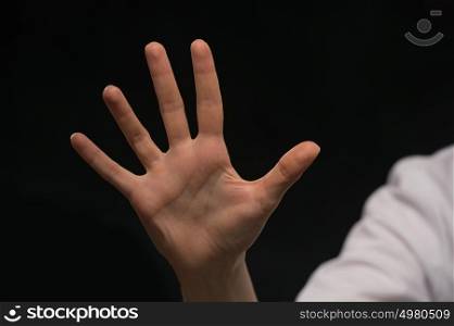 Female hand is showing five fingers isolated on black background