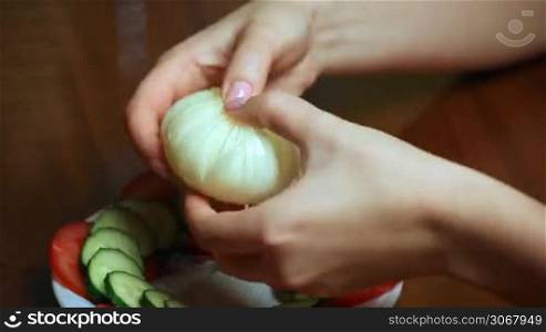 female hand making chrysanthemum from onion closeup