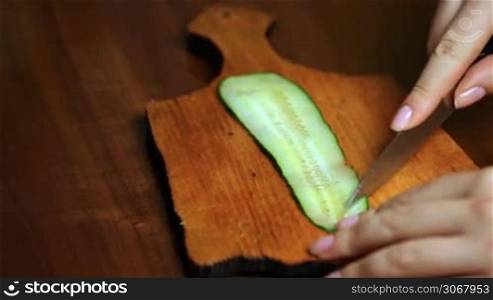 female hand making flower from strip of cucumber closeup single