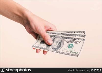 female hand on a light background. female hand holding dollars bills