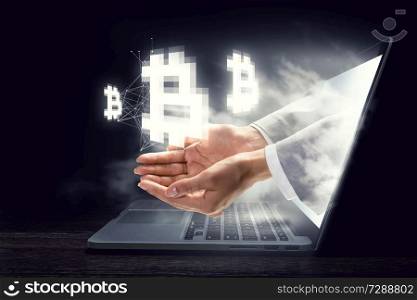 Female hand out of laptop screen presenting bitcoin concept. 3D rendering. Crypto currency concept. Mixed media