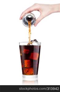 Female hand pouring cola soda drink from bottle to glass with ice cubes on white background