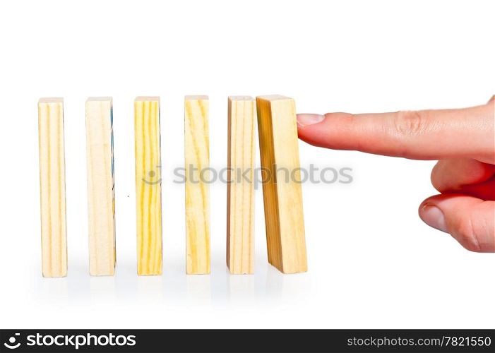female hand pushing a row of dominoes lined up