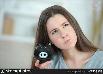 female hand putting coin into piggy bank isolated on white