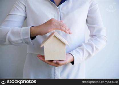Female hand saving house security real estate and property insurance concept