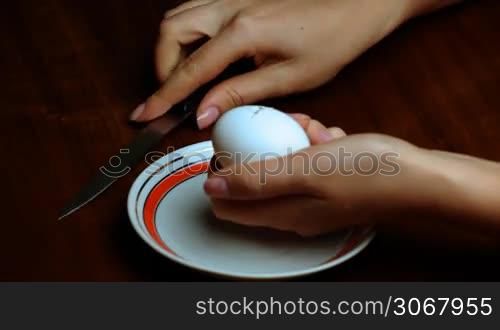 female hand separating yolk from egg white closeup