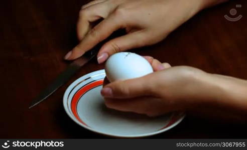 female hand separating yolk from egg white closeup