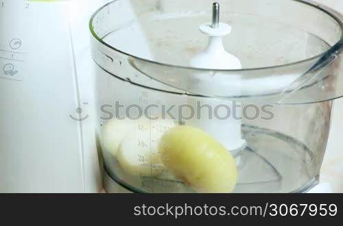female hand using kitchen unit cut pieces of onion timelaps closeup