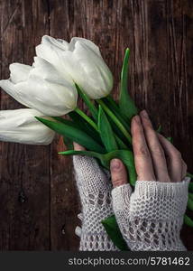 female hand with a bouquet of fresh white tulips