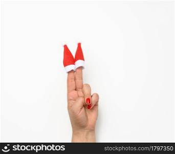 female hand with handsome red christmas caps on fingers, white background