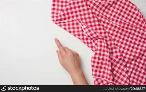 female hand with raised forefinger and red kitchen napkin on white table, top view