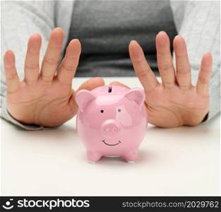 female hands and pink ceramic piggy bank. Accumulation concept, budget control