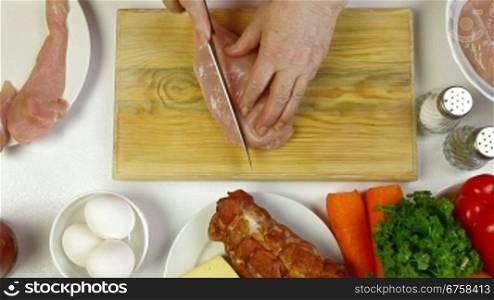 Female Hands cutting chicken breast