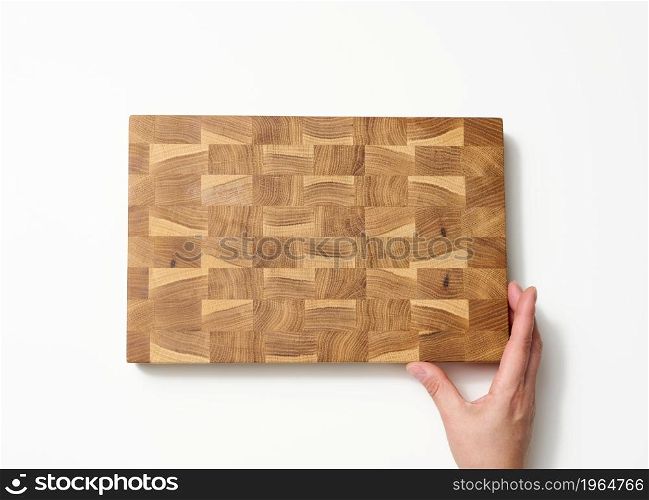 female hands hold empty rectangular brown wooden chopping board on white background