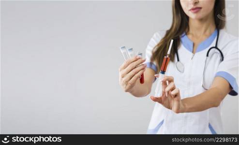 female hands holding blood samples syringe