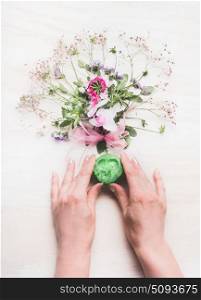 Female hands holding natural handmade green soap with fragrant herbs and flowers , Organic Soap making, top view. Cosmetic, skincare and beauty concept