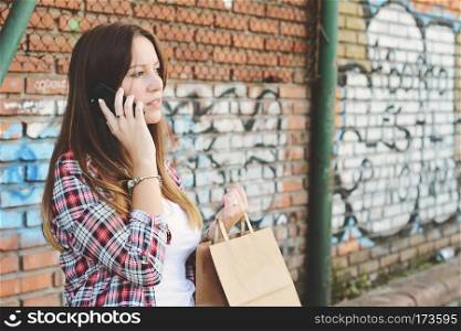 Female hands holding shopping bag outdoors. Woman in shopping. Consumerism and lifestyle concept.