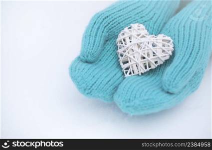 Female hands in mittens with heart, close-up