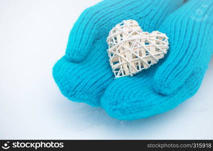 Female hands in mittens with heart, close-up