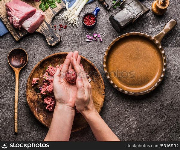 Female hands making meat balls on kitchen table background with meat, force meat , meat grinder and spoon, top view. Cooking,recipes and eating concept