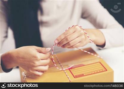Female hands packing box at warehouse, online marketing concept