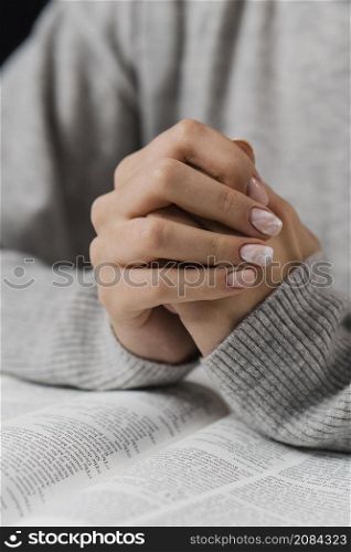 female hands praying position with bible