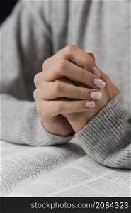 female hands praying position with bible