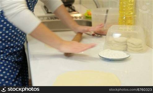 Female Hands Rolls Out Dough For Pies On Counter Top